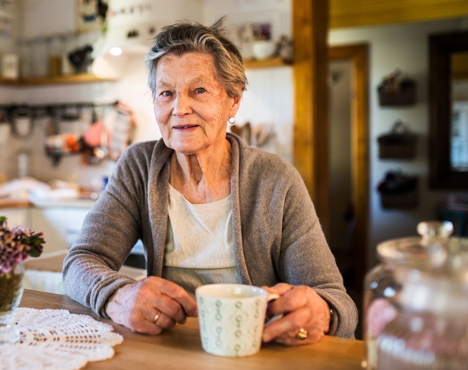 Older adult woman enjoys cup of coffee at her table