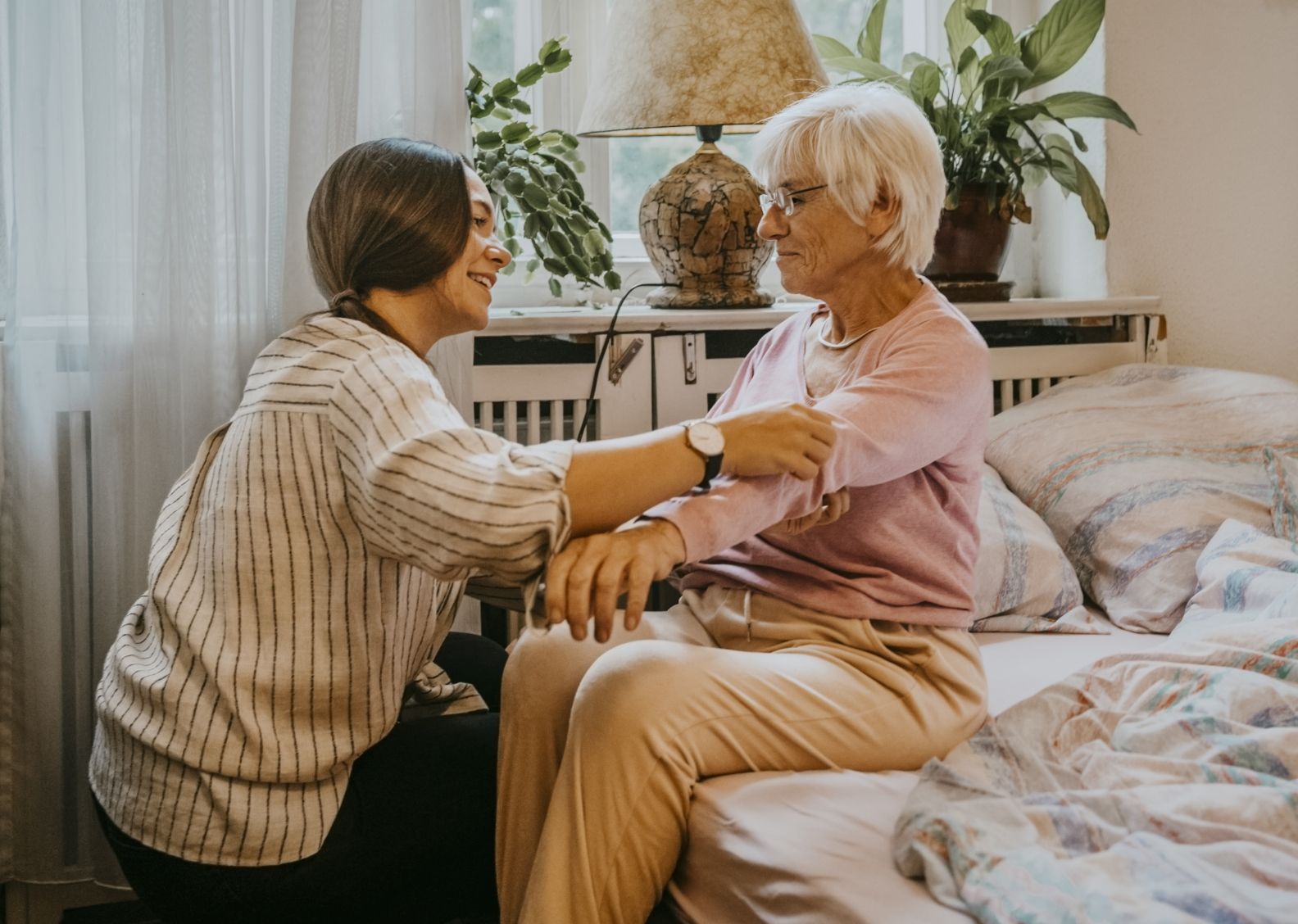 Physical Therapist adjusts arm of an older adult client.