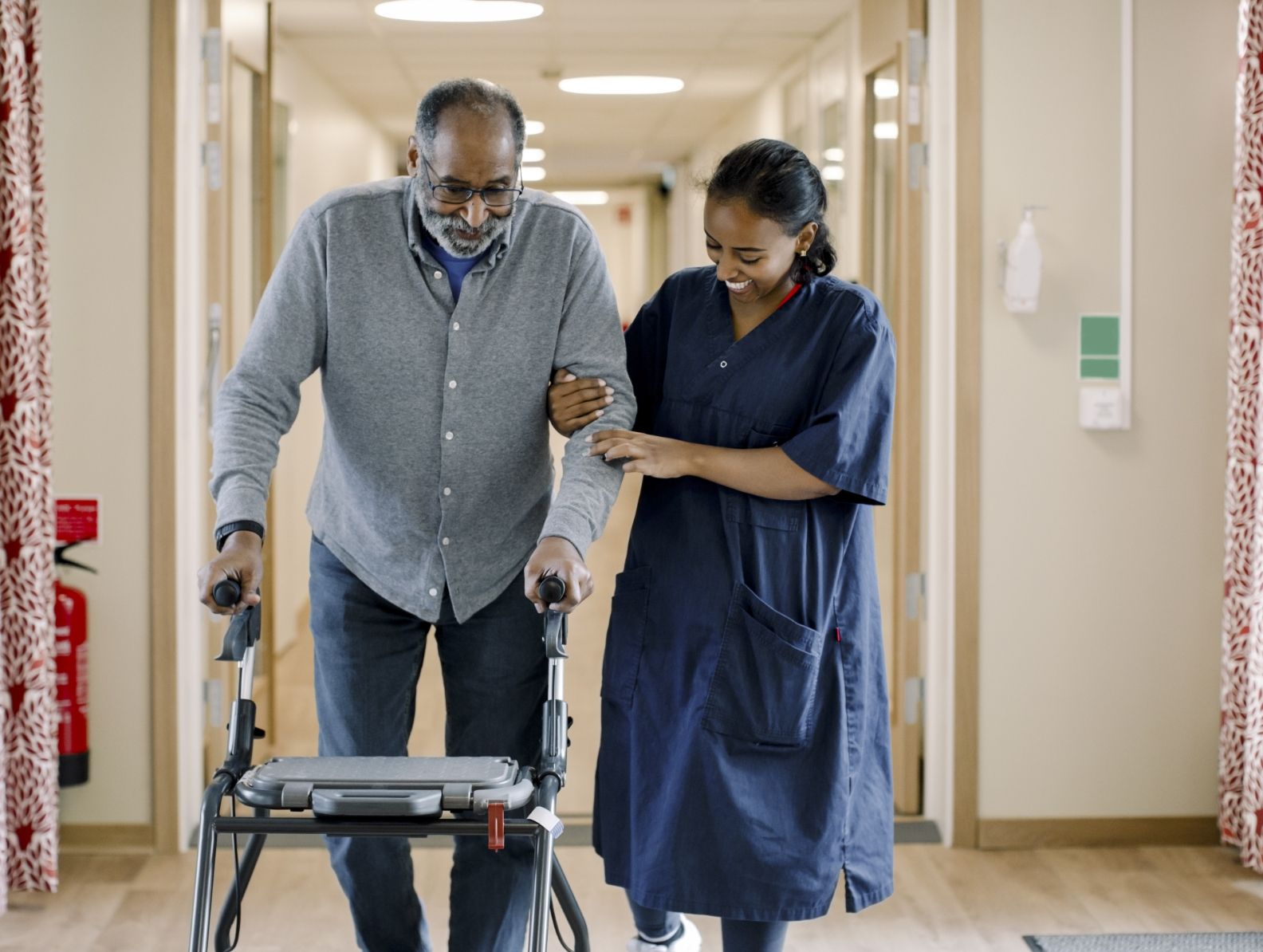 Woman helps older adult walk with a walker